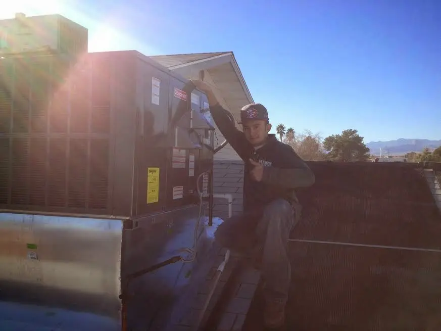 HVAC technician performing HVAC Inspection on a rooftop unit in Aloha